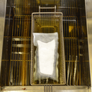 A FreshFry Pod placed in a fryer basket, inserted into a Fryer.